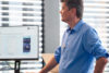 Ein SAP-Experte erklärt im Rahmen einer EWM-Schulung RF-Transaktionen an einem Monitor.