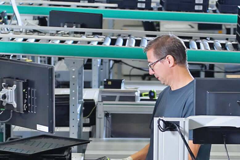 Lagermitarbeiter an einem Ware-zur-Person-Arbeitsplatz für das Kommissionieren mit SAP